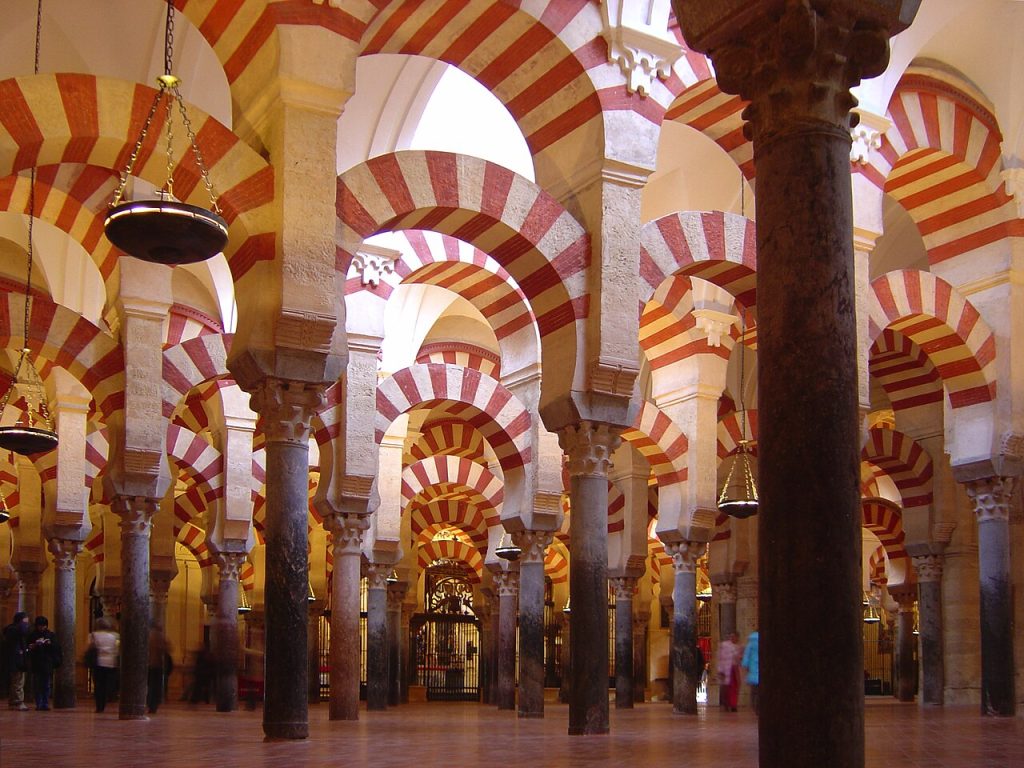 Interior de la Mezquita de Córdoba con columnas y arcos superpuestos de dovelas rojas y blancas